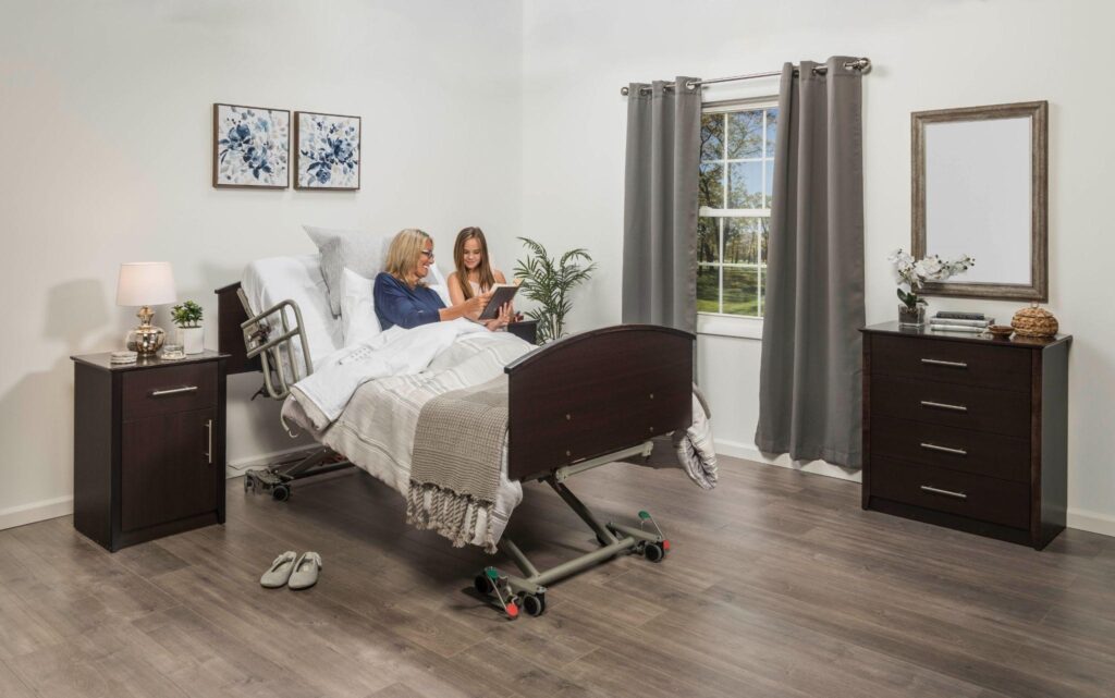 Grandmother and granddaughter reading together on an adjustable electric hospital bed