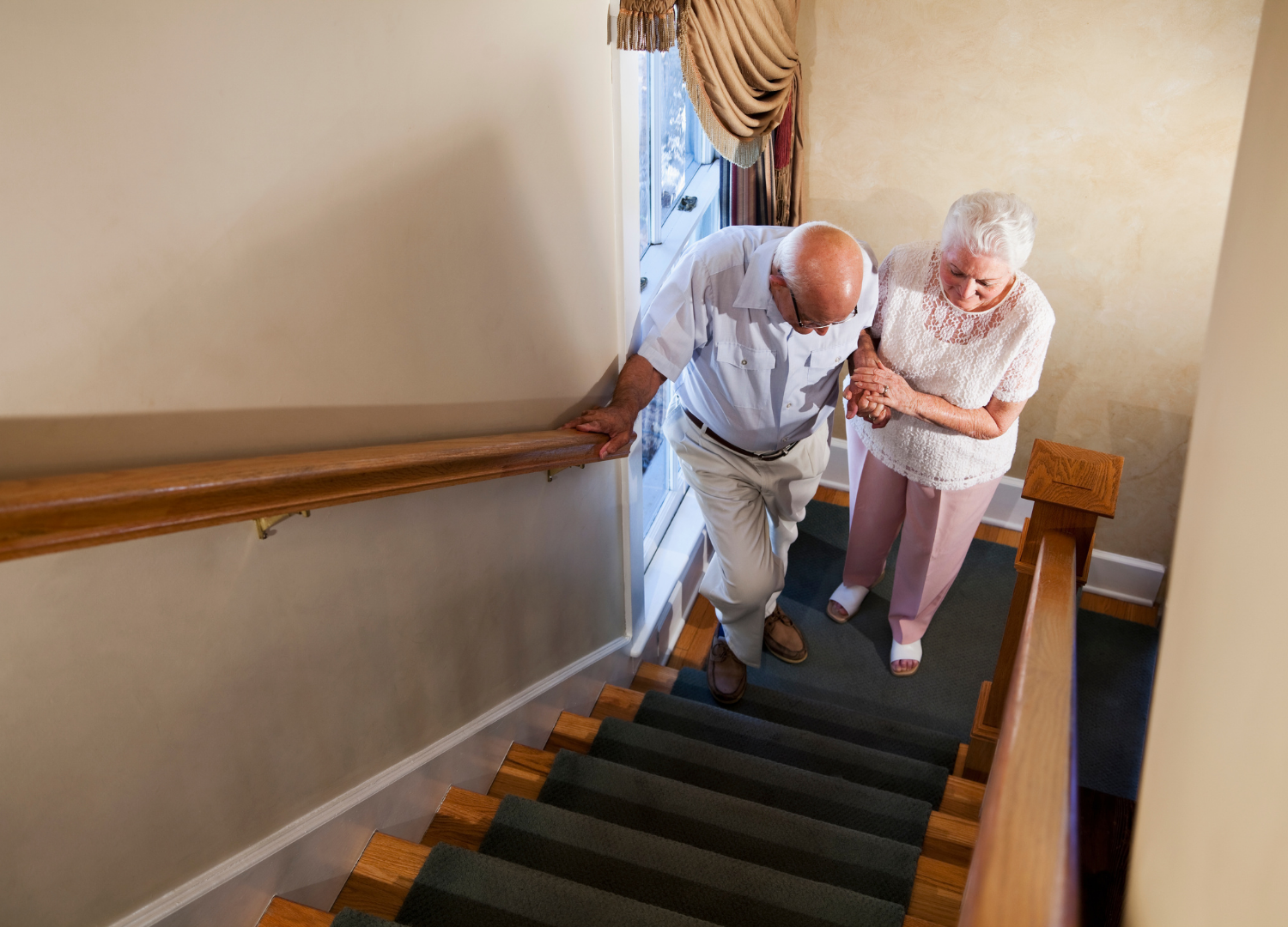 older woman helping an older man up stairs